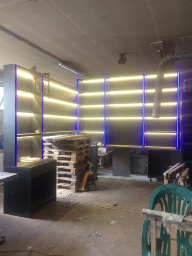 Moderne Wandregale mit LED-Beleuchtung in einem unordentlichen Raum.