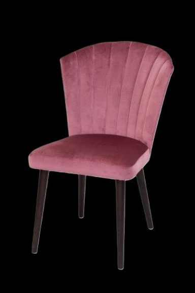 Rosa Velours-Stuhl mit geschwungenem Rücken und dunklen Beinen auf schwarzem Hintergrund.
