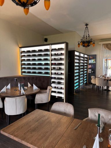 Elegante Restaurantinneneinrichtung mit Tischen und einem Weinschrank.