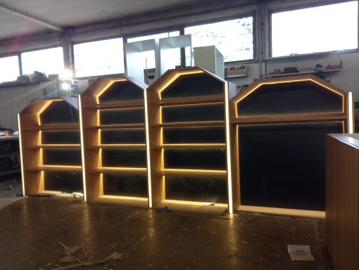 Drei hölzerne Regale mit LED-Beleuchtung in einem Raum.