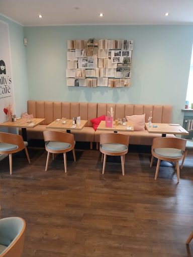 Heller Restaurantbereich mit Holzmöbeln und dekorativer Wandkunst.