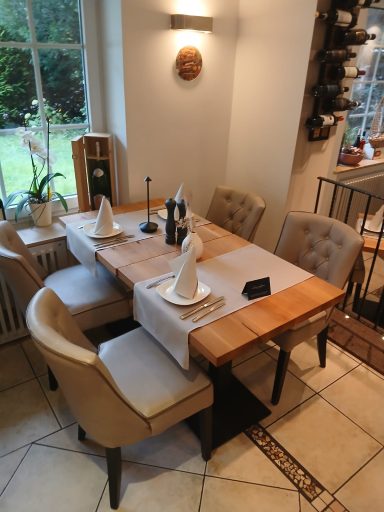 Ein eleganter Essbereich mit einem Holz-Tisch, Stühlen und gedecktem Tisch.