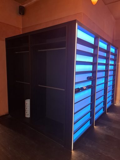 Schwarze Kabinen mit blauer Beleuchtung in einem Raum.