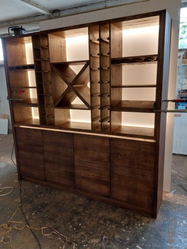 Holzregal mit beleuchteten Fächern und geschlossenen Türen, modern und elegant gestaltet.