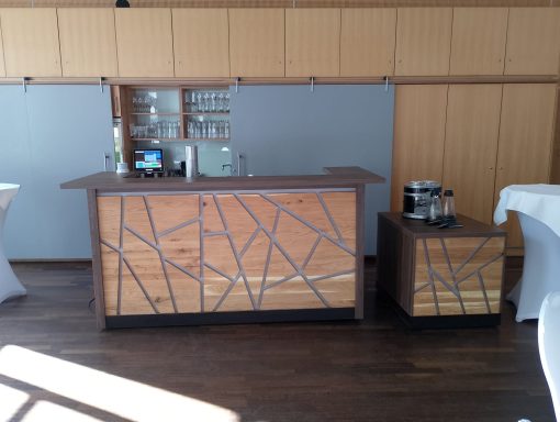 Moderne Bar aus Holz mit dekorativen Metallakzenten und zwei Hockern.