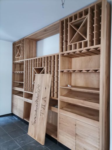Wandregal aus Holz mit offenen Fächern und Schubladen, noch unvollständig.